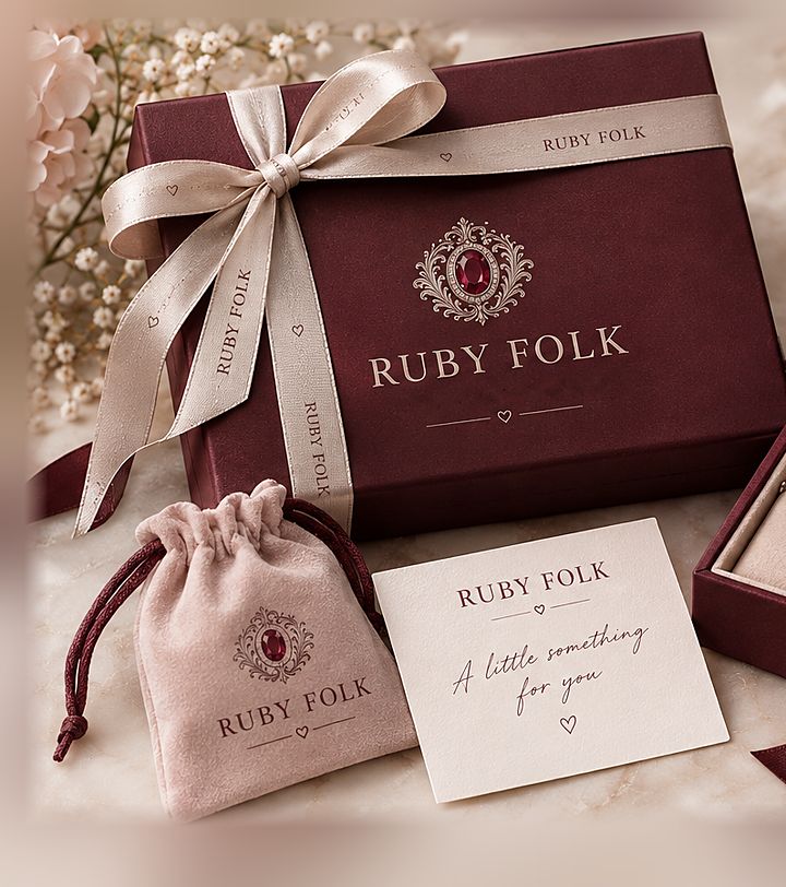 Ruby Folk burgundy gift box tied with champagne ribbon, blush velvet pouch and ivory note card